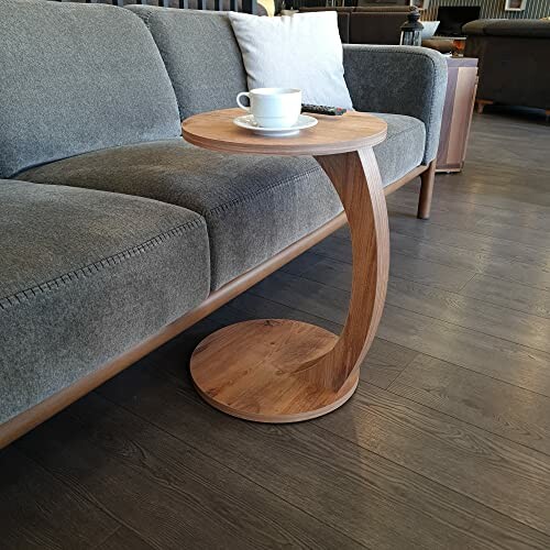 Table d'appoint en bois avec une tasse de café sur un canapé.